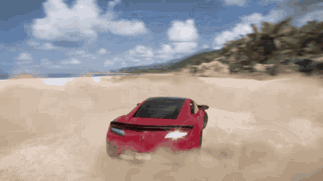 a red sports car is driving through a sandy desert