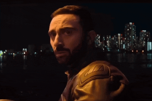 a man with a beard is wearing a leather jacket with the letter a on the shoulder